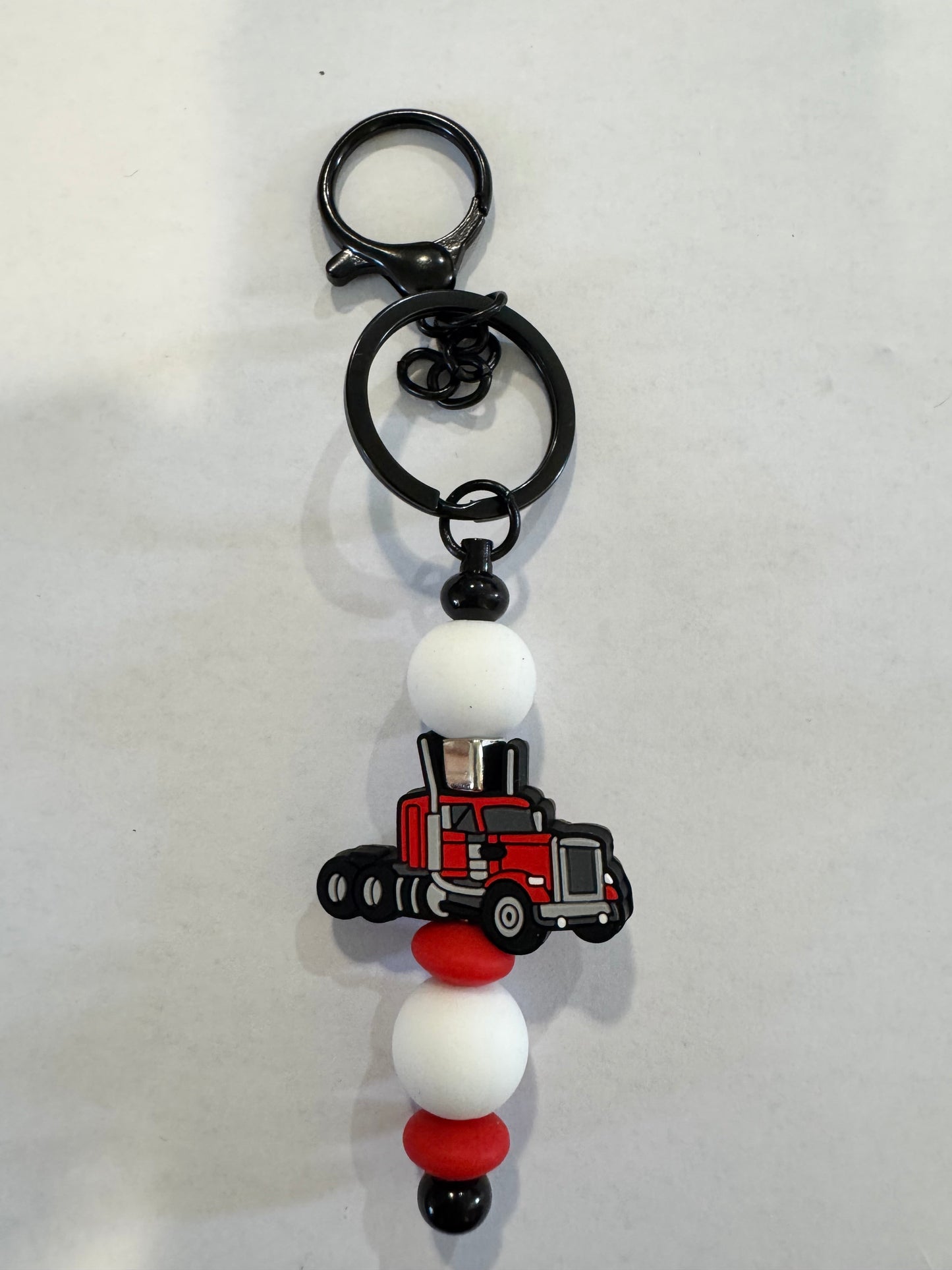Keychain with a TRUCK charm and beads on a white background