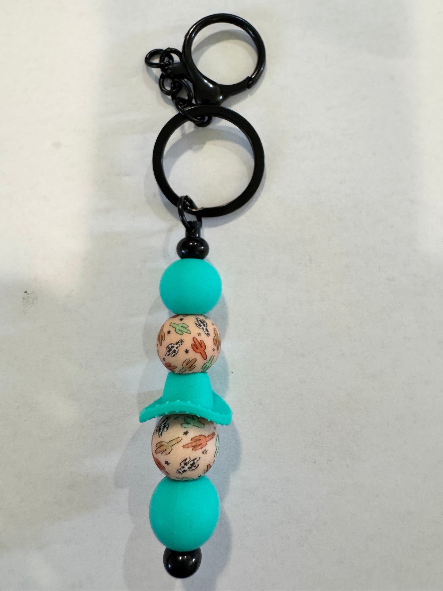 Keychain with floral-patterned beads and a black ring on a white background