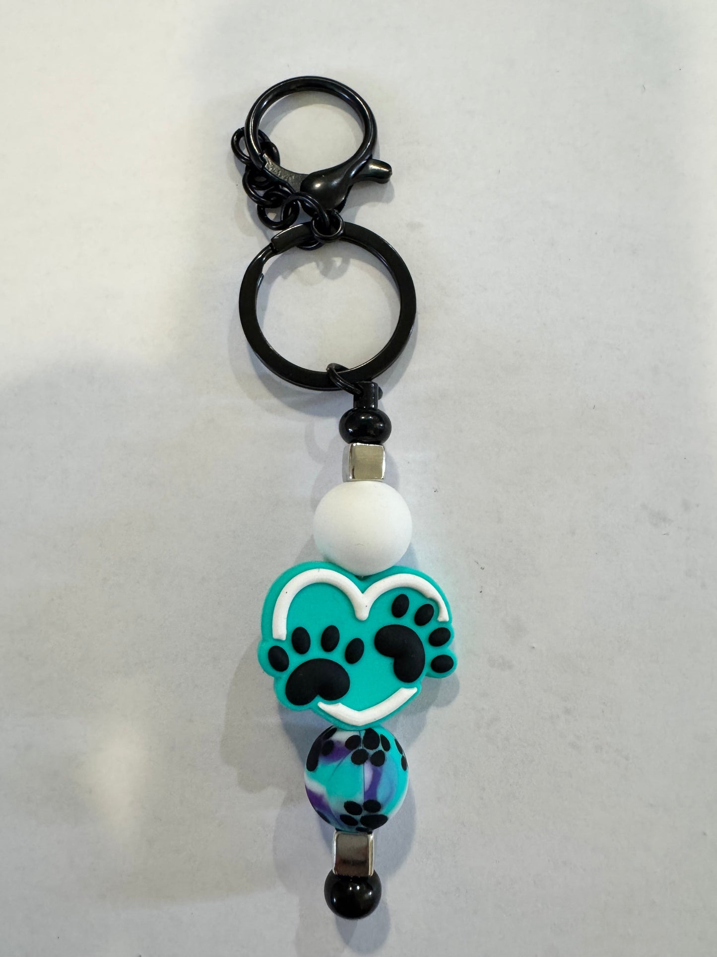 Keychain with paw print design on a light gray background