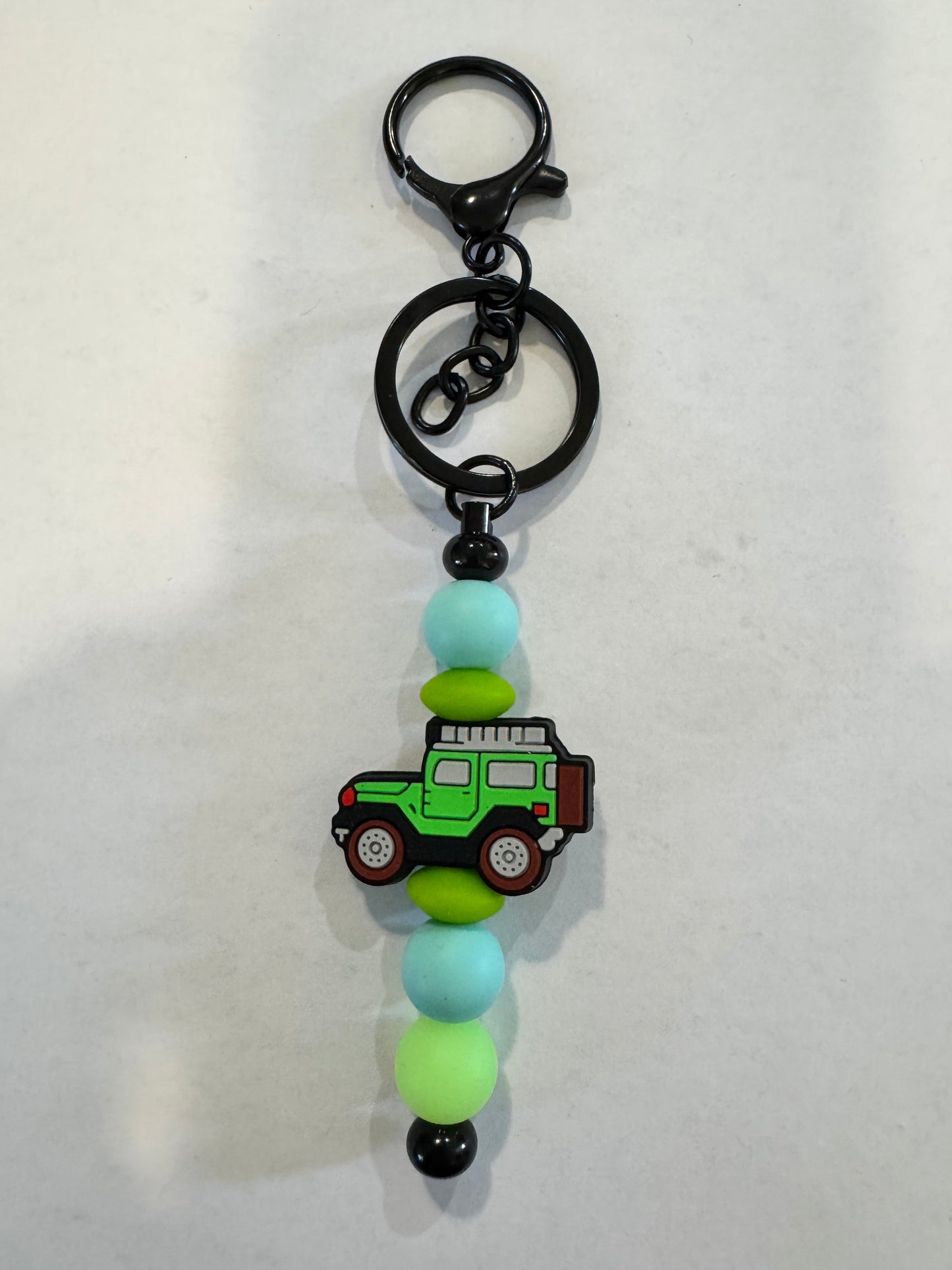 Keychain with green JEEP charm and colourful beads on a white background