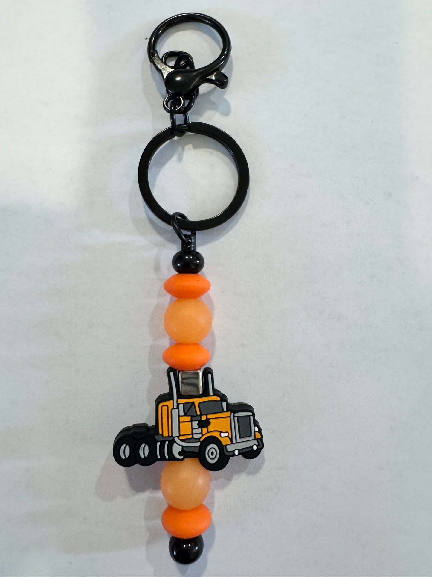 Keychain with toy truck and beaded design on a white background