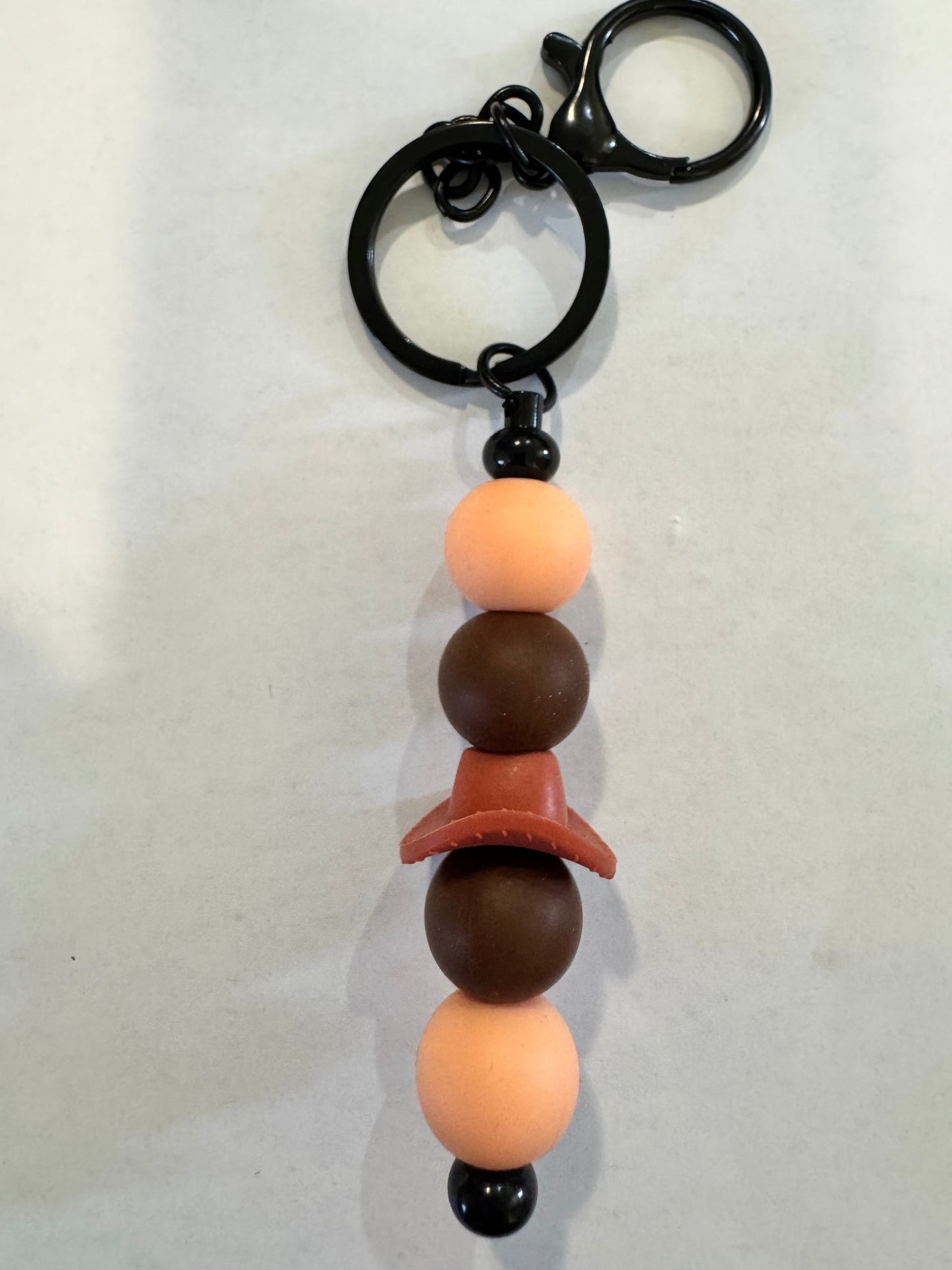 Keychain with pacifier attachment featuring pink and brown beads on a white background