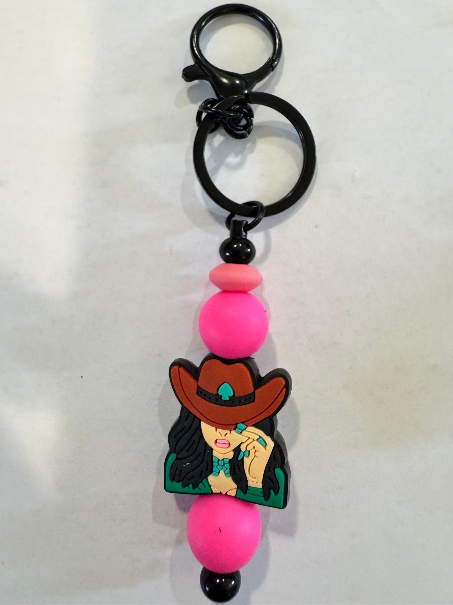 Keychain with cartoon character and pink beads on a white background