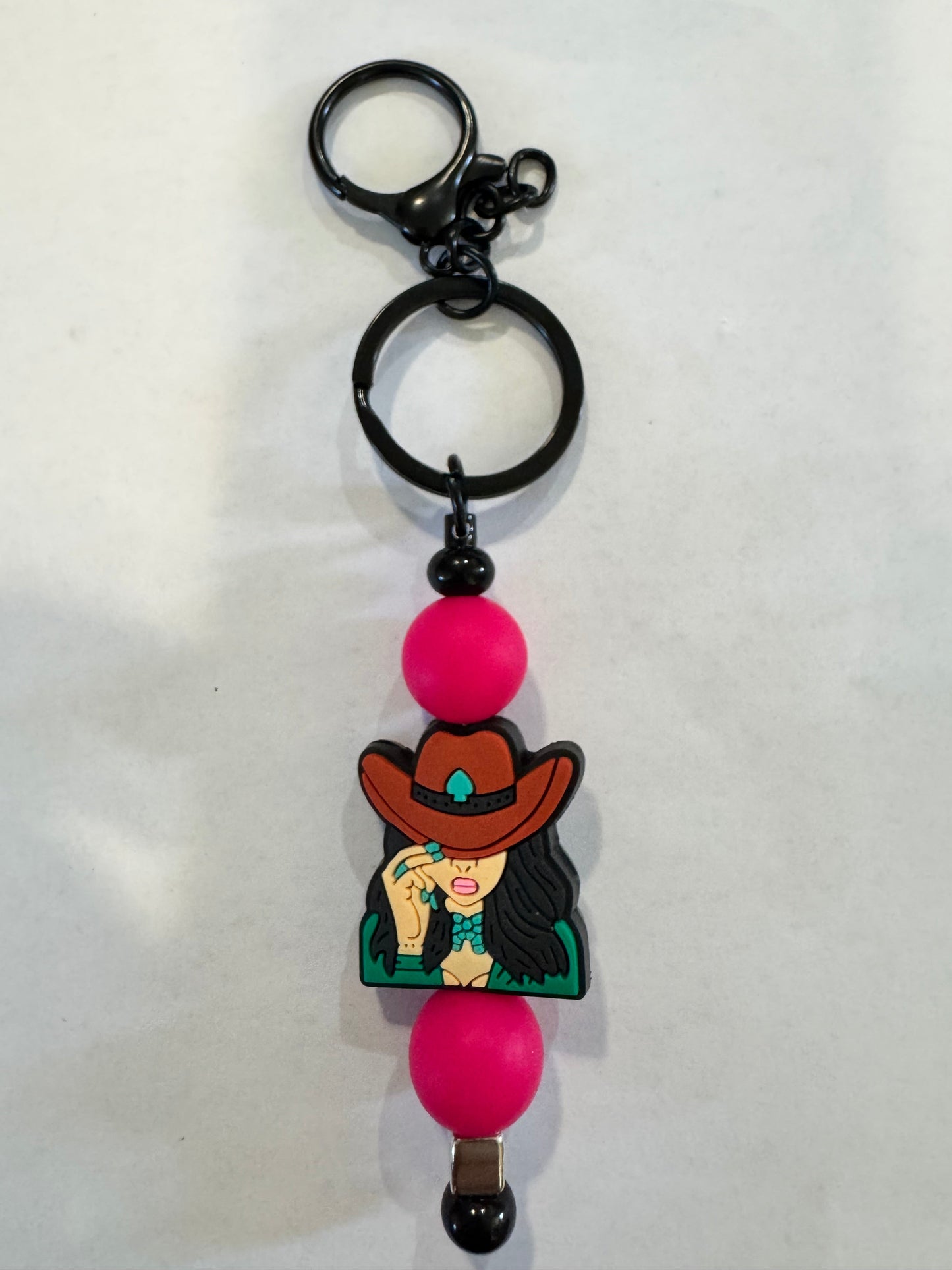 Keychain with cartoon character and pink beads on a white background