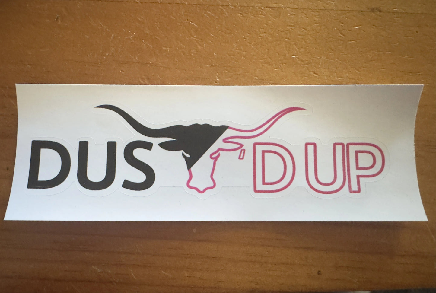 Sticker with 'DUSt'd up text on a white background